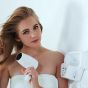 A beautiful woman uses the white hair dryer. 