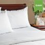 A bed with two pillows using Swiss Stripes.