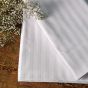 The Swiss Stripes sheets were laid on a wood table with flowers. 