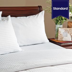 A bed with two pillows using Swiss Stripes.